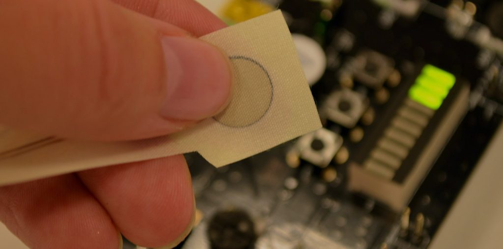 Close-up of a person pushing a button on a modern control panel